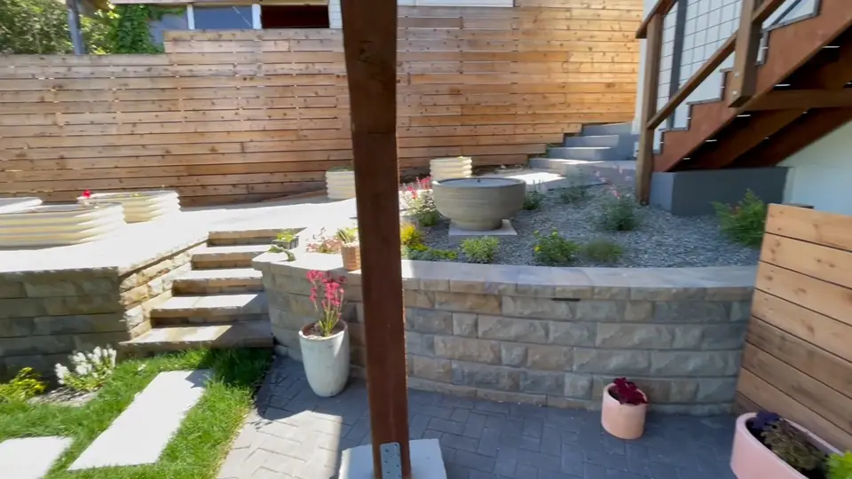 Terraced block retaining walls with concrete steps under a deck